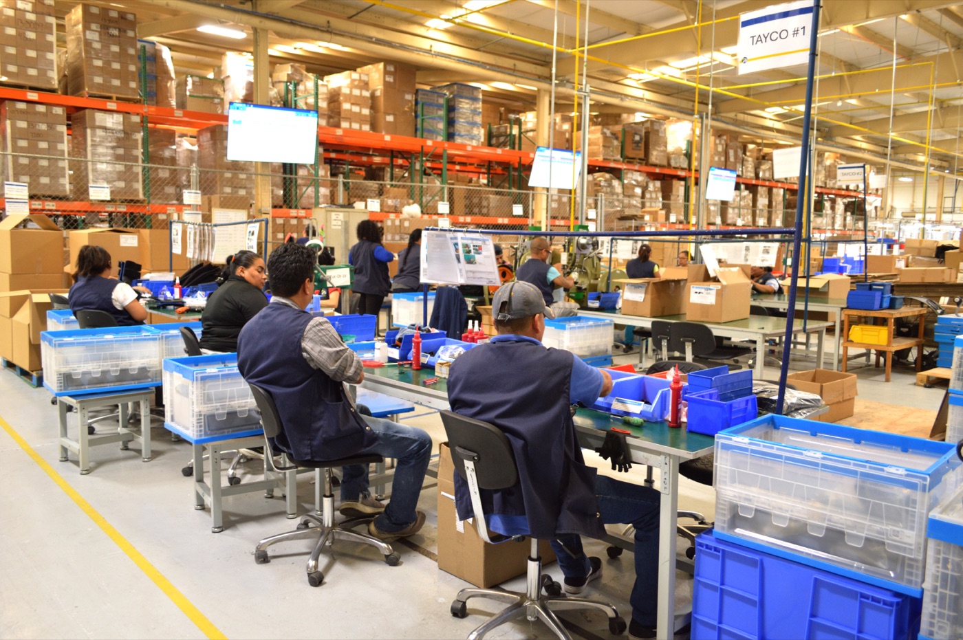 Tutamen Tijuana Plant 03 — assembly cell with operators at workstations branded TAYCO #1 and TAYCO #2